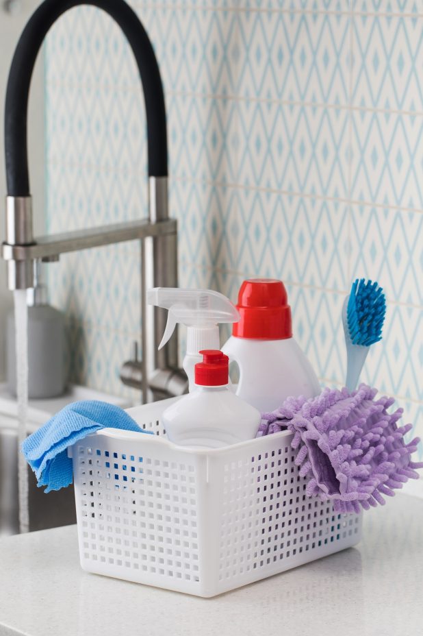 Cleaning products for cleaning, disinfection at home in a basket in kitchen.