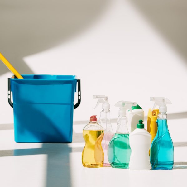 various cleaning products, mop and bucket on white